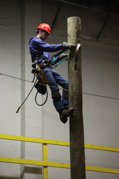 EDET student demonstrating climbing telephone poles.